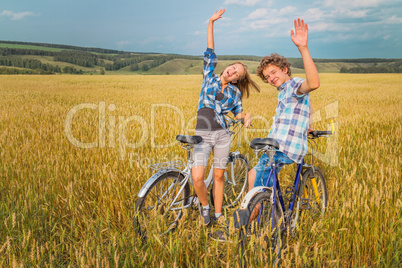 Portrait of a teen on a bike against the blue cloudy sky and yel
