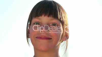 Portrait of a European boy fun talking to the camera. Face emotional child against the sky, a white background.