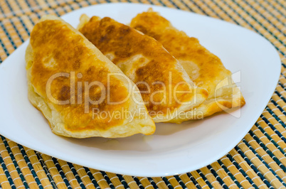 Chebureks on the table on a white plate