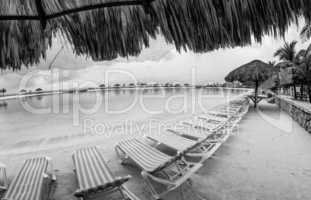 Straw umbrella and chairs on the beach of Roatan, Honduras