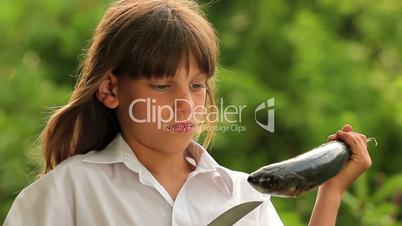 Boy holding a marine fish.Child preparing fish.Little cook.