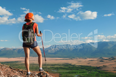 Pretty young woman tourist standing on top of mountain