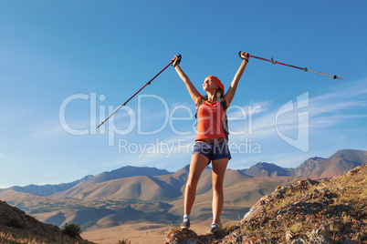 Pretty young woman tourist standing on top of mountain