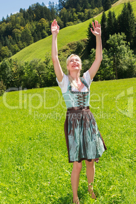 Attraktive blonde Frau in einem Dirndl ist voller Freude