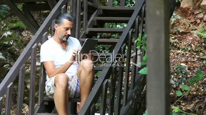 middle age brunette man using digital tablet