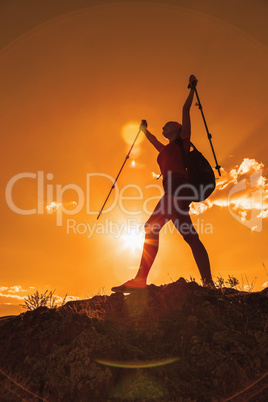 Silhouette of pretty young woman tourist standing on top of moun