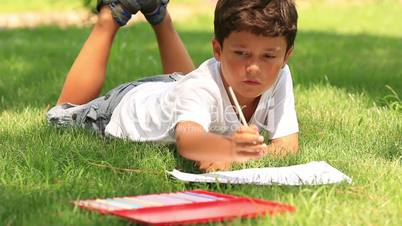 child drawing on the grass