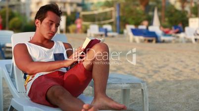 attractive young man reading a book
