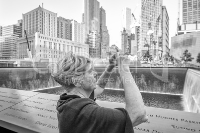 Tourist woman in 70s making pictures to amazing New York skyline