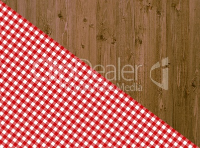 Holztisch mit diagonaler Tischdecke in rot-weiß