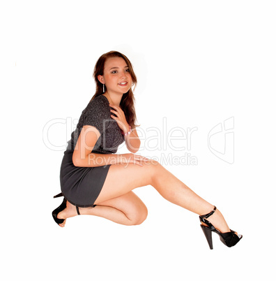 Teen girl kneeling on floor.