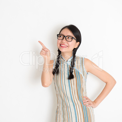 Asian Chinese girl pointing on blank copy space