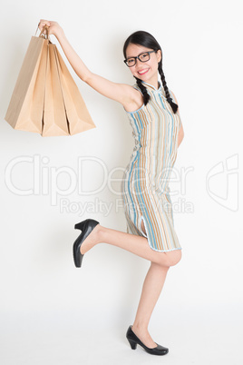 Asian Chinese girl hands holding paper shopping bags