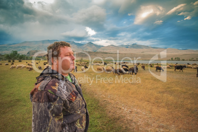 A man and a herd of goats and sheep