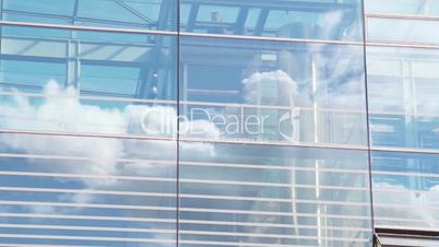Glashaus mit Wolkenspiegelung