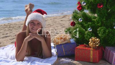 Girl in Santa hat celebrating Christmas on tropical beach