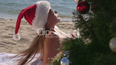 Girl in Santa hat enjoying Christmas holidays on the beach resort