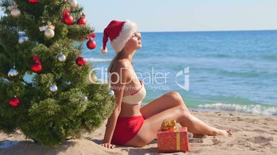 Girl in Santa hat enjoying Christmas vacation time on beach resort
