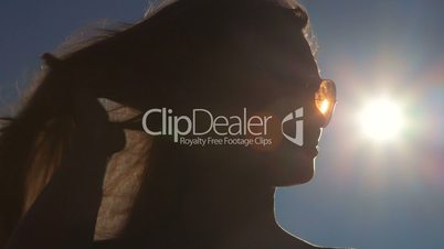 Woman face in sunglasses against the sun