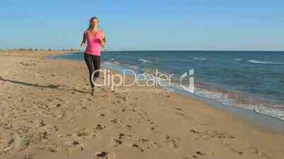 Fitness sporty girl running on the beach during daily workout