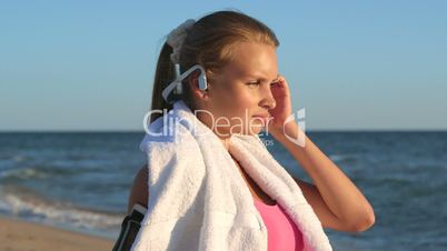 Face of fitness girl relax listening to music after workout on the beach