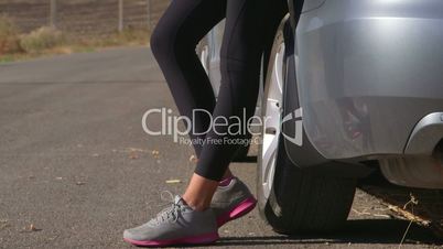 Sporty driver woman traveling by car with bicycle on bike roof carrier