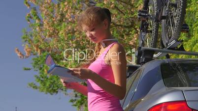 Young woman driver traveling by car with bicycle on roof
