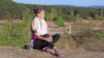Fitness young woman relaxing after workout exercise on nature