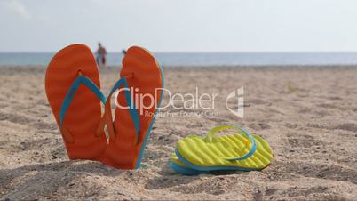 Pair of flip flops on a sandy beach in summer