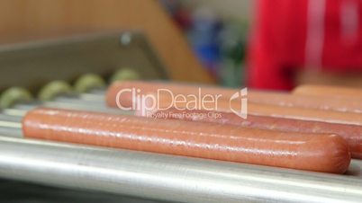Commercial hot dog roller grill cooker heats rotating sausages