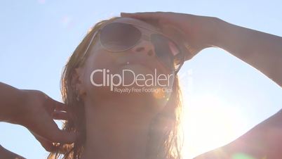Young girl wearing aviator sunglasses after swimming in sunshine at the beach