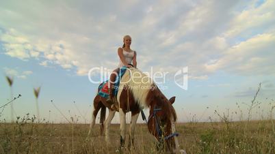 Horseback riding vacations girl rider with her horse in the field