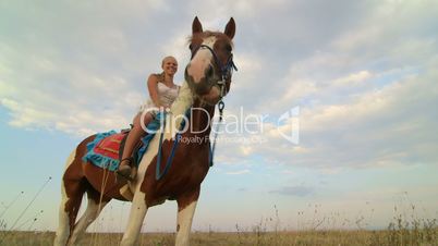 Horseback riding vacations girl rider with her horse in the field