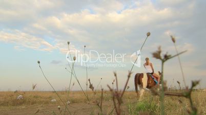 Horseback riding vacations girl rides horse away in field