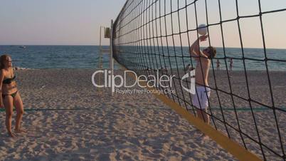 Young couple spend a weekend playing beach volleyball