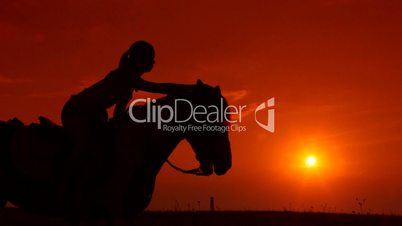 Horseback riding silhouette of girl on horse at sunset