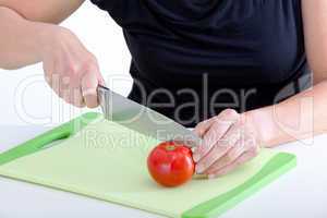Woman with knife cut the tomato