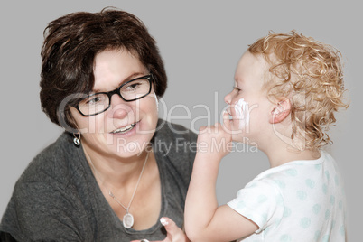 Woman putting cream on a playful child