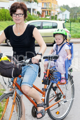 Woman with child rides a bicycle