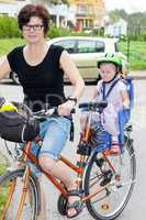 Woman with child rides a bicycle