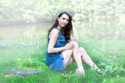 Woman sitting in foggy park by the lake