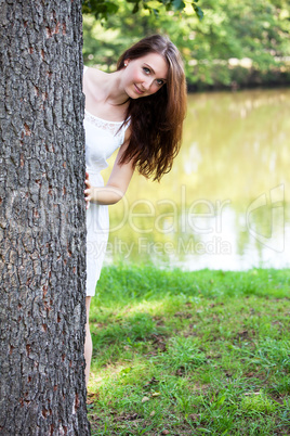 Woman hiding behind the tree