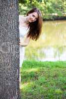 Woman hiding behind the tree