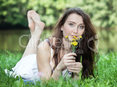 Woman with small bouquet of flowers lying in the park