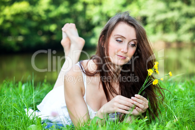 Woman with small bouquet of flowers lying in the park