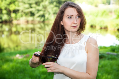 Woman in the park combing her long hair