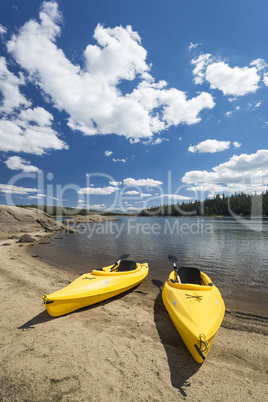 Pair of Yellow Kayaks on Beautiful Mountain Lake Shore.