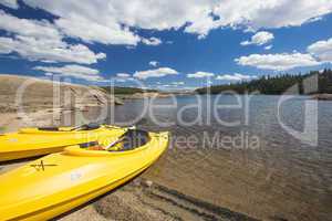 Pair of Yellow Kayaks on Beautiful Mountain Lake Shore.