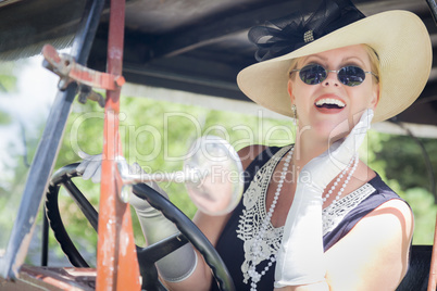 Attractive Woman in Twenties Outfit Driving an Antique Automobil