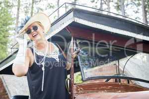 Attractive Woman in Twenties Outfit Near Antique Automobile